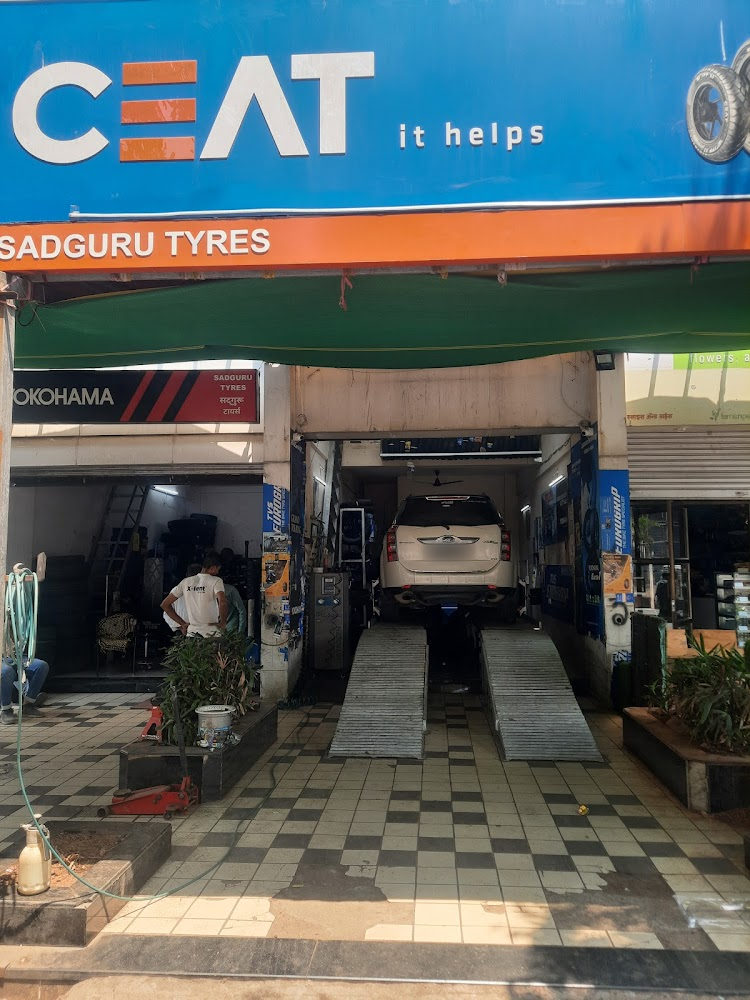 Sadguru Tyres CEAT bays with cars on ramps